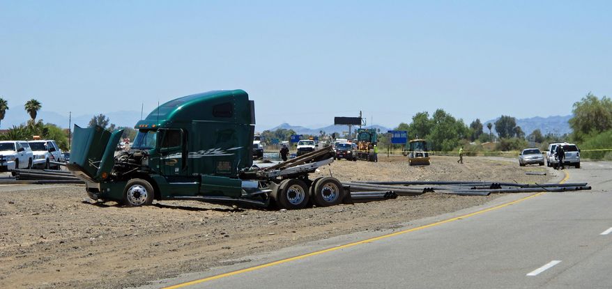 Emergency personnel respond to the scene of a fatal accident in Blythe, Calif. on Wednesday, May 21, 2014. A tractor-trailer spilled a load of steel pipes onto a highway, triggering a bus crash Wednesday that killed four people and seriously injured several others on the main road linking Southern California and Arizona, authorities said. (AP Photo/Brian Skoloff)