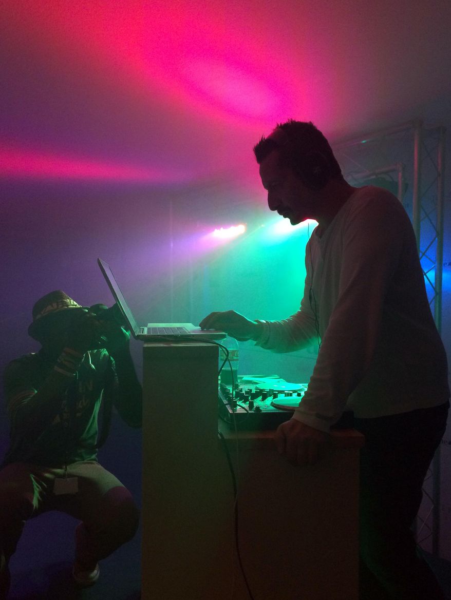 In this photo taken on Wednesday, May 21, 2014, a DJ plays music at the American Pavilion tent in Cannes, southern France. On Wednesday night, one of the more unusual events was among the quietest. A so-called “Silent Disco” party at the American Pavilion tent, had party-goers dancing along to music that was booming not from speakers, but from individual wireless headphones. (AP Photo/Nekesa Moody)
