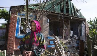 Zinaida Patskan, 80, stands in front of her destroyed house following a shelling from Ukrainian government forces in Semyonovka village near the major highway which links Kharkiv, outside Slovyansk, Ukraine, Thursday, May 22, 2014. The election is a critical step for Ukraine. Russia, which the West alleges is fomenting the unrest that grips Ukraine’s eastern regions, claims the acting government is a junta; a credible election would bring a level of legitimacy to the government and undermine Moscow’s argument. (AP Photo/Alexander Zemlianichenko)