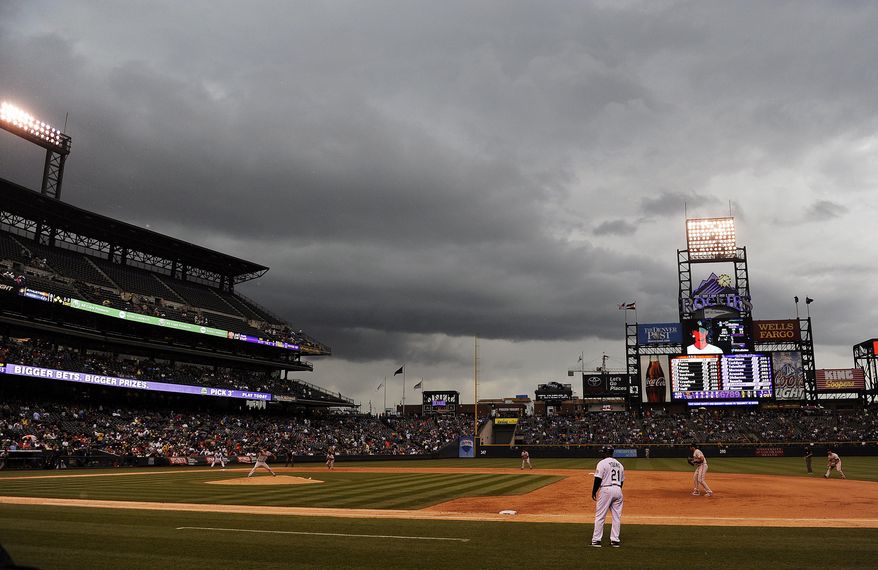 Storm clouds gather above Coors Field in the sixth inning of a baseball game between the San Francisco Giants and the Colorado Rockies on Thursday, May 22, 2014, in Denver. The game was suspended due to weather and will be replayed in September. (AP Photo/Chris Schneider)