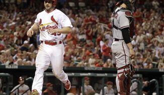 St. Louis Cardinals&#x27; Shane Robinson, left, scores on a single by Matt Carpenter as Arizona Diamondbacks catcher Tuffy Gosewisch stands by during the eighth inning of a baseball game Thursday, May 22, 2014, in St. Louis. (AP Photo/Jeff Roberson)