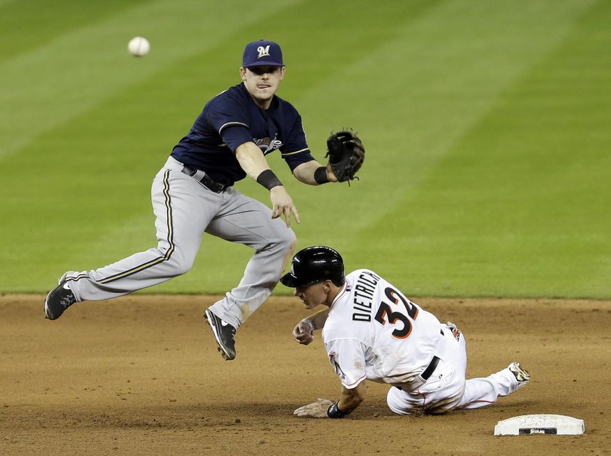 Milwaukee Brewers second baseman Scooter Gennett throws to first base after forcing out Miami Marlins' Derek Dietrich (32) at second base, Casey McGehee was safe at first base on a fielder's choice in the eighth inning of a baseball game in Miami, Friday, May 23, 2014. The Brewers won 9-5. (AP Photo/Alan Diaz)