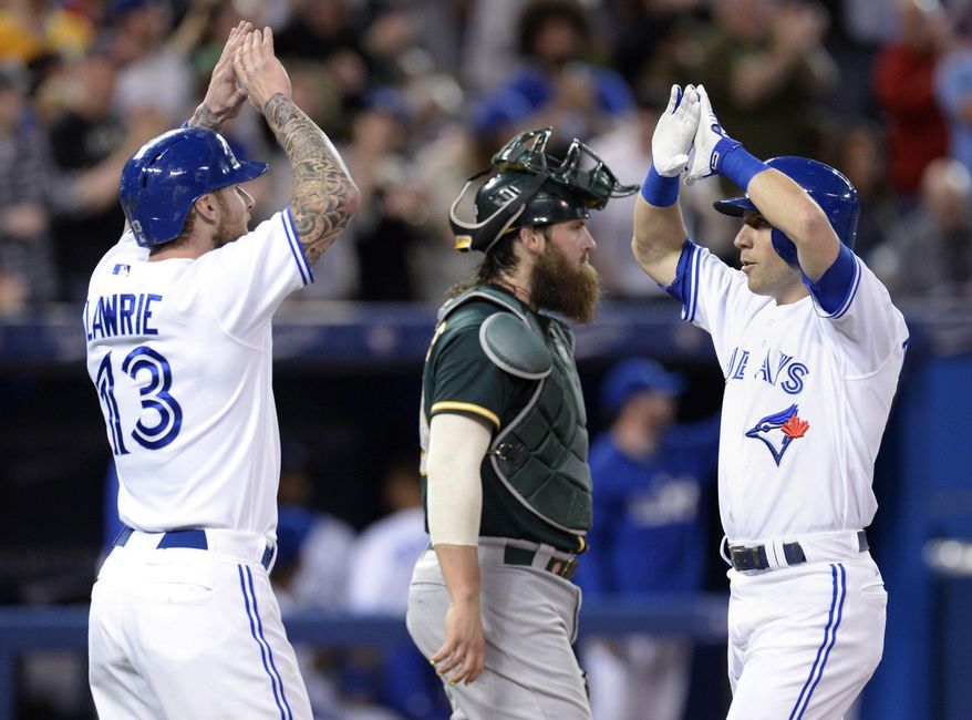 Toronto Blue Jays&#39; Steve Tolleson, right, celebrates his two-run home run with Brett Lawrie as Oakland Athletics catcher Derek Norris stands next to them during the second inning of a baseball game Friday, May 23, 2014, in Toronto. (AP Photo/The Canadian Press, Frank Gunn)