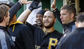 Pittsburgh Pirates&#x27; Russell Martin, center, celebrates in the dugout after scoring from third on a wild pitch by Washington Nationals starting pitcher Jordan Zimmermann during the second inning of a baseball game in Pittsburgh, Friday, May 23, 2014. (AP Photo/Gene J. Puskar)