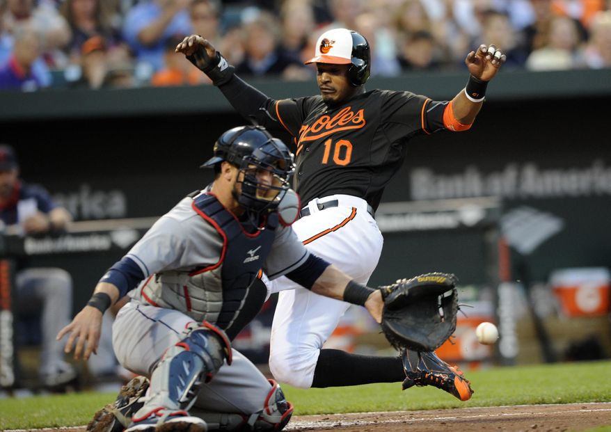 Baltimore Orioles&#39; Adam Jones (10) comes in to score on a double by Chris Davis during the third inning of a baseball game, against Cleveland Indians catcher Yan Gomes on Friday, May 23, 2014, in Baltimore. (AP Photo/Nick Wass)