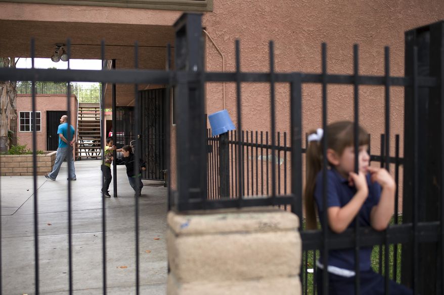 Young boys play in the courtyard at an apartment building, where kidnapping suspect Isidro Garcia lived, on Thursday, May 22, 2014, in Bell Gardens, Calif. A woman who disappeared a decade ago as a 15-year-old reunited recently with her mother, who convinced her to go to authorities to report that she had been kidnapped and raped by a man who is now her husband and father of her daughter. (AP Photo/Jae C. Hong)