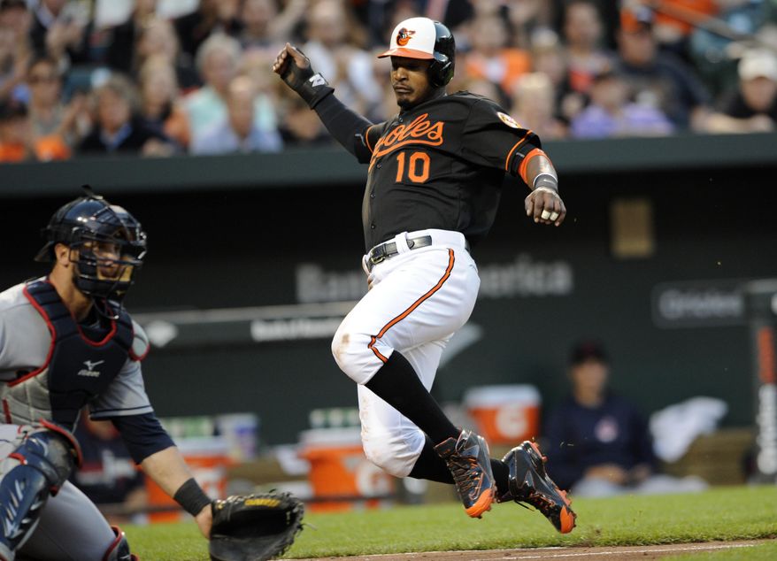 Baltimore Orioles&#39; Adam Jones (10) comes in to score on a double by Chris Davis against Cleveland Indians catcher Yan Gomes during the third inning of a baseball game Friday, May 23, 2014, in Baltimore. (AP Photo/Nick Wass)