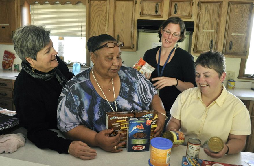 Helpmate staff organize groceries in the shelter kitchen Monday, May 19, 2014. From left, Ann Flynn, associate director; Joy Henderson; Jodi Wygman; April Burgess-Johnson, executive director. Helpmate is a shelter and assistance program for victims of domestic violence. (AP Photo/Asheville Citizen-Times, Bill Sanders)