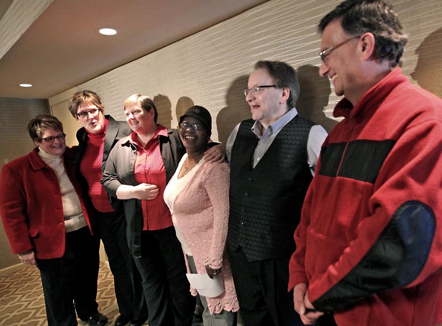 FILE - In this Feb 3, 2014 file photo, plaintiffs in a federal lawsuit challenging Wisconsin's ban on gay marriage appear during a press conference at the Madison Concourse Hotel in Madison, Wis. U.S. Van Hollen on Friday, May 23, 2014 asked a federal judge to place on hold any future order she may make that would strike down the state’s ban on gay marriage, the second time this week Van Hollen expressed doubt in the state’s chances to succeed in defending the law. The American Civil Liberties Union filed a lawsuit on behalf of eight gay couples in February challenging Wisconsin's constitutional ban on gay marriage. The lawsuit contends the state's ban denies gay couples the civil rights that other married couples enjoy. (AP Photo/Wisconsin State Journal, John Hart)