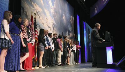 This May 21, 2014 photo provided by the North Dakota Petroleum Council shows a group of eight-graders from West Fargo’s Cheney Middle School standing behind North Dakota Attorney General Wayne Stenehjem as he addresses the Williston Basin Petroleum Conference in Bismarck, N.D. The students were at the conference to present projects addressing problems caused by or related to oil development in the state. (AP Photo/North Dakota Petroleum Council, Renae Mitchell)