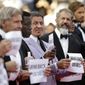 From third left, actors Harrison Ford, Wesley Snipes, Sylvester Stallone, Mel Gibson and Antonio Banderas, from the movie The Expendables 3, hold up signs as they arrive for the screening of The Homesman at the 67th international film festival, Cannes, southern France, Sunday, May 18, 2014. (AP Photo/Thibault Camus)