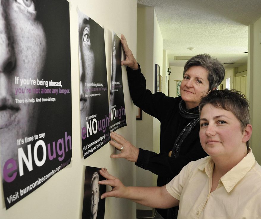 Helpmate executive director April Burgess-Johnson (foreground) and associate director Ann Flynn with posters for the Bumcombe County's new domestic violence plan Monday, May 19, 2014. Helpmate is a shelter and assistance program for victims of domestic violence. (AP Photo/Asheville Citizen-Times, Bill Sanders)