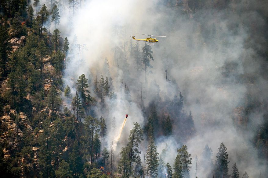 Helicopters drop water on part of the Slide Fire in Sterling Canyon at the Oak Creek Overlook above Sedona, Ariz. on Thursday, May 22, 2014. Hundreds of firefighters worked Thursday to protect communities on the edge of Flagstaff from a wildfire that is chewing up a scenic Arizona canyon with towering flames and burning entire trees down to nothing but ash. (AP Photo/The Arizona Republic, Michael Schennum) MARICOPA COUNTY OUT; MAGS OUT; NO SALES