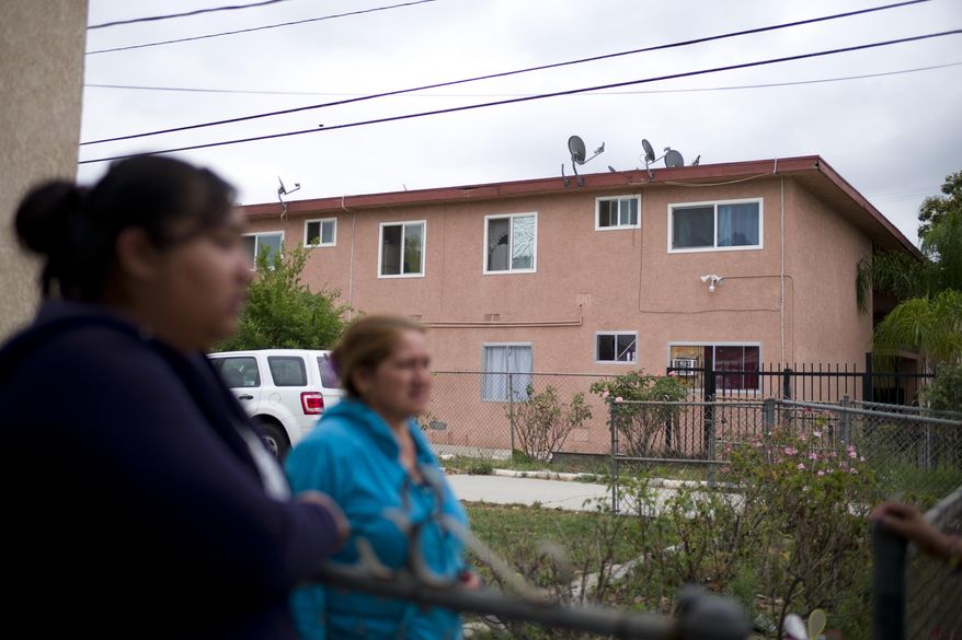 A group of women from the neighborhood chat near an apartment building where suspect Isidro Garcia lived on Thursday, May 22, 2014, in Bell Gardens, Calif. A woman who disappeared a decade ago as a 15-year-old reunited recently with her mother, who convinced her to go to authorities to report that she had been kidnapped and raped by Garcia who is now her husband and father of her daughter. (AP Photo/Jae C. Hong)