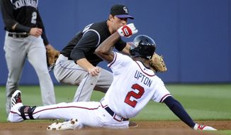 Atlanta Braves&#39; B.J. Upton (2) safely slides into second base on a double as Colorado Rockies&#39; DJ LeMahieu turns to try to tag him during the first inning of a baseball game Friday, May 23, 2014, in Atlanta. (AP Photo/David Tulis)
