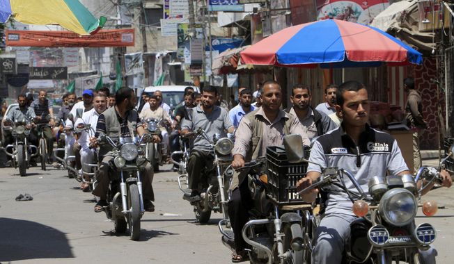 Palestinian Hamas supporters ride their motorcycles during a rally to support Palestinian prisoners on hunger strike at Israeli jails, in Khan Younis, in the southern Gaza Strip on Friday, May 23, 2014. (AP Photo/Adel Hana)
