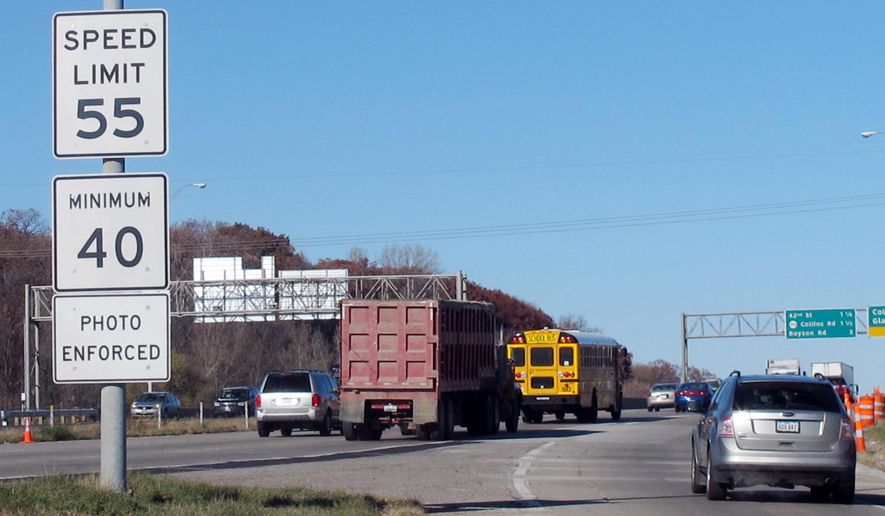 FILE - In this Nov. 12, 2013, file photo, vehicles pass a highway sign along Interstate 380 in Cedar Rapids, Iowa, warning drivers that the 55-mph speed limit is enforced by speed cameras. Six Iowa cities have submitted reports outlining traffic camera use to state transportation officials and now await word on whether they’ll be able to keep their speed and red light cameras on state-run highways and interstates. (AP Photo/Ryan J. Foley, File)