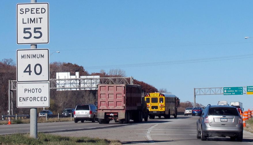 FILE - In this Nov. 12, 2013, file photo, vehicles pass a highway sign along Interstate 380 in Cedar Rapids, Iowa, warning drivers that the 55-mph speed limit is enforced by speed cameras. Six Iowa cities have submitted reports outlining traffic camera use to state transportation officials and now await word on whether they’ll be able to keep their speed and red light cameras on state-run highways and interstates. (AP Photo/Ryan J. Foley, File)