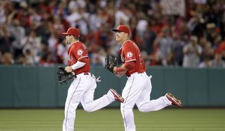 Los Angeles Angels&#39; Collin Cowgill, left, and Mike Trout head back to the dugout after the top of the fifth inning of a baseball game against the Kansas City Royals on Friday, May 23, 2014, in Anaheim, Calif. (AP Photo/Jae C. Hong)