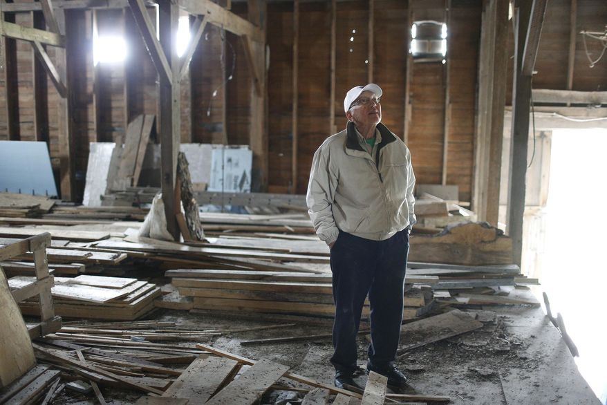 In a Friday, May 9, 2014 photo, Robert Jefferson, 86, looks over the barn where he unloaded hay as a young boy on his Heritage Farm in Dunkerton, Iowa. Jefferson's Heritage Farm is 158 years old, and one of only 10 in Black Hawk County that have earned the Heritage designation from the Iowa Department of Agriculture and Land Stewardship. (AP Photo/Waterloo Courier, Matthew Putney)