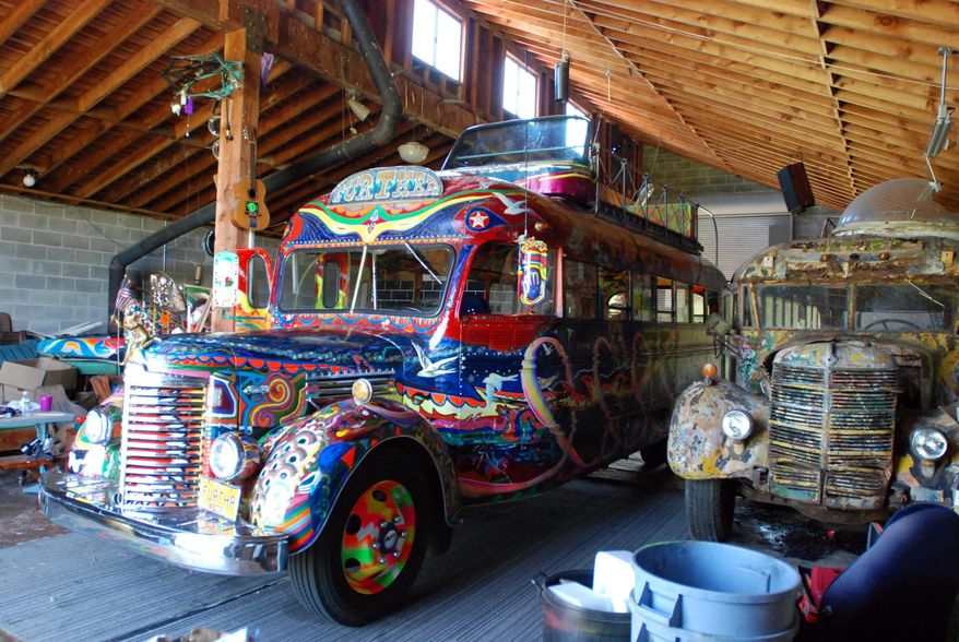 The original 1939 International bus dubbed Further and ridden on a cross-country trip in 1964 by author Ken Kesey and his friends, the Merry Pranksters, right, sits in a barn in Pleasant Hill, Ore., on May 14, 2014. Next to it, left, is a newer version of the bus that Kesey's son, Zane, plans to put back on the road for a 50th anniversary commemoration of the trip that became an icon of the psychedelic 1960s. (AP Photo/Jeff Barnard)