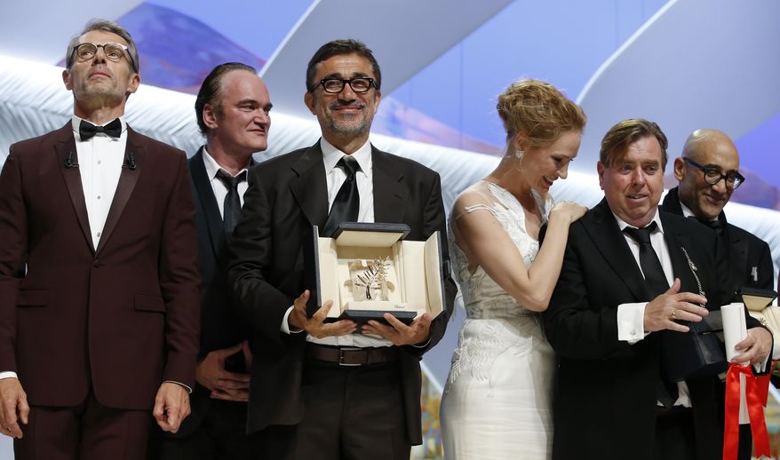 Director Nuri Bilge Ceylan, center, poses with the Palme d'Or award for the film Winter Sleep and Actor Timothy Spall, second right, poses with his award for Best Actor for his role in the film Mr. Turner during the awards ceremony for the 67th international film festival, Cannes, southern France, Saturday, May 24, 2014. At third right is presenter actress Uma Thurman and at second left is director and presenter Quentin Tarantino. (AP Photo/Alastair Grant)