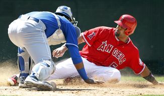 Kansas City Royals catcher Salvador Perez, left, tags out Los Angeles Angels&#39; Albert Pujols (5) who was attempting to score from second base on a single hit by Angels&#39; C.J. Cron for the last out of the seventh inning of a baseball game on Sunday, May 25, 2014, in Anaheim, Calif. (AP Photo/Alex Gallardo)