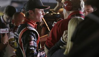 Driver Kurt Busch sips on a drink as he talks to the media after dropping out of the NASCAR Sprint Cup series Coca-Cola 600 auto race at Charlotte Motor Speedway in Concord, N.C., Sunday, May 25, 2014. (AP Photo/Chuck Burton)