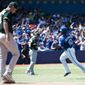 Toronto Blue Jays first baseman Edwin Encarnacion, right, rounds the bases past Oakland Athletics starting pitcher Drew Pomeranz, left, after hitting a solo home run during the fourth inning of a baseball game in Toronto on Sunday, May 25, 2014. (AP Photo/The Canadian Press, Nathan Denette)