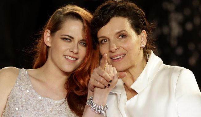 Actress Kristen Stewart, left, and actress Juliette Binoche pose for photographers following the screening of Sils Maria at the 67th international film festival, Cannes, southern France, Friday, May 23, 2014. (AP Photo/Thibault Camus)