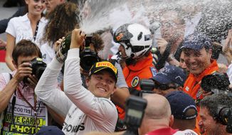 Mercedes driver Nico Rosberg of Germany sprays champagne after winning the Monaco Formula One Grand Prix, at the Monaco racetrack, in Monaco, Sunday, May 25, 2014.  Nico Rosberg won the Monaco Grand Prix from pole position on Sunday to take the overall championship lead from his teammate Lewis Hamilton, who finished second to give Mercedes a fifth straight 1-2 finish. The German driver clinched his second victory of the season and fifth of his career, making a strong start and holding off Hamilton to repeat his maiden GP win from pole here in Monaco last year. (AP Photo/Luca Bruno)