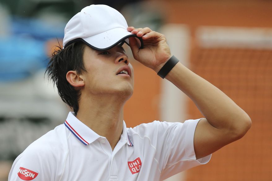 Japan's Kei Nishikori adjusts his cap in the first round match of the French Open tennis tournament against Slovakia's Martin Klizan at the Roland Garros stadium, in Paris, France, Monday, May 26, 2014. Nishikori lost in three sets 6-7, 1-6, 2-6. (AP Photo/David Vincent)