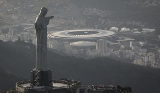 In this May 13, 2014, photo,This aerial view shot through an airplane window shows the Maracana stadium behind the Christ the Redeemer statue in Rio de Janeiro, Brazil. As opening day for the World Cup approaches, people continue to stage protests, some about the billions of dollars spent on the World Cup at a time of social hardship, but soccer is still a unifying force. The international soccer tournament will be the first in the South American nation since 1950. (AP Photo/Felipe Dana, File)