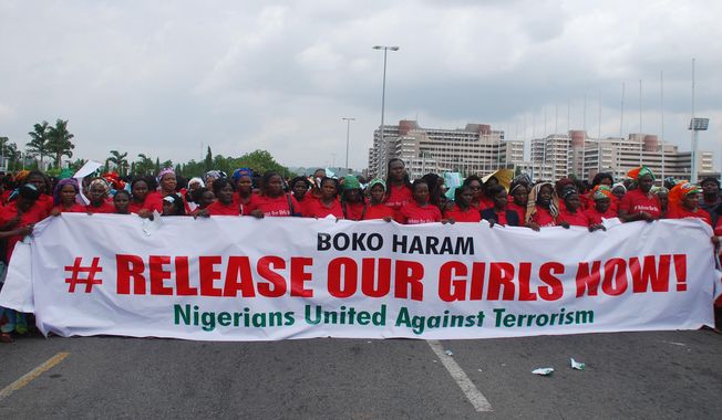 In this Monday, May 26, 2014, photo, the Nigerians United Against Terrorism group attends a demonstration calling on the government to rescue the kidnapped girls of the government secondary school in Chibok, in Abuja, Nigeria.  Nigeria&#x27;s defense chief said Monday that the military has located nearly 300 school girls abducted by Islamic extremists but cannot use force to free them. (AP Photo/Gbenga Olamikan)