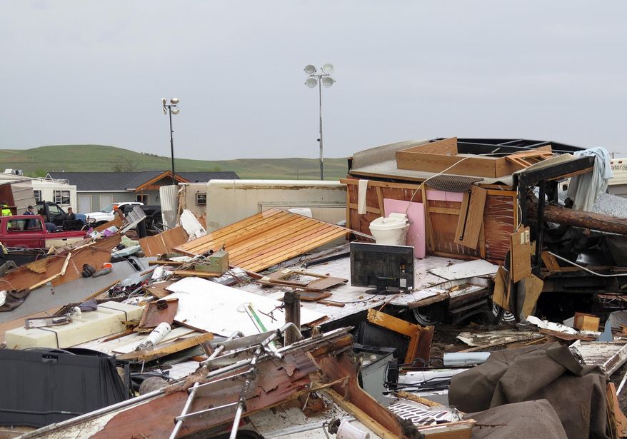 Debris from a destroyed trailer is scattered Tuesday morning, May 27, 2014, after a tornado in Watford City, N.D. Authorities say at least eight trailers were destroyed Monday evening when the twister tore through a camp where oil field workers stay. Nine people were injured, including a 15-year-old girl critically. (AP Photo/Josh Wood)