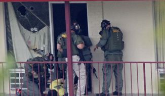 Knoxville police SWAT team officers examine a suspect outside a room at the Days Inn hotel Tuesday, May 27, 2014, in Knoxville, Tenn. (AP Photo/Wade Payne) ** FILE **