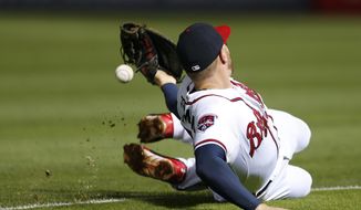 Atlanta Braves first baseman Freddie Freeman can&#39;t reach an RBI single by Boston Red Sox&#39;s Jonny Gomes in the seventh inning of a baseball game Tuesday, May 27, 2014, in Atlanta. (AP Photo/John Bazemore)