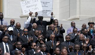 Some of the more than 200 Arkansas pastors opposed to same-sex marriage applaud at a rally on the steps of the Arkansas State Capitol in Little Rock in this May 27, 2014, file photo. (Associated Press) ** FILE **