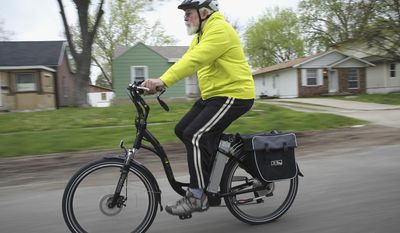 In this May 2, 2014 photo, David Lasley rides his electric bike in Springfield, Ill. He uses his customized electric bicycle to commute between his north-end Springfield home and work. (AP Photo/The State Journal-Register, Rich Saal)