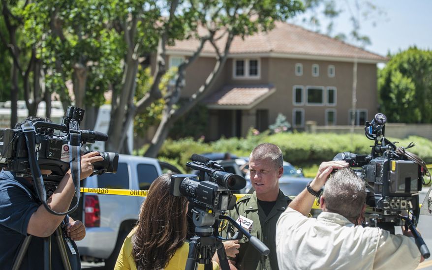 Lt. Jeff Hallock of the Orange County Sheriff's Department speaks with the media about the discovery of four bodies in the home behind him in Mission ViejoTuesday morning, May 27, 2014. The bodies were found by Orange County deputies making a welfare check after a relative's emergency call, sheriff's Lt. Jeff Hallock said. (AP Photo/The Orange County Register, Mark Rightmire) MAGS OUT; LOS ANGELES TIMES OUT ///ADDITIONAL INFORMATION: 4dead – 5/27/14 – MARK RIGHTMIRE, ORANGE COUNTY REGISTER -