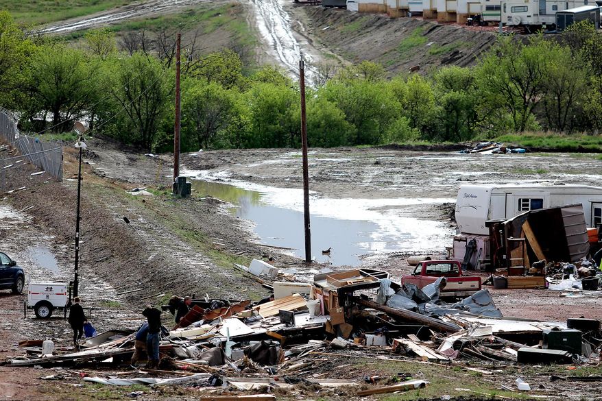 People search through wreckage Tuesday, May 27, 2014, after a tornado in Watford City, N.D. Authorities say at least eight trailers were destroyed Monday evening when the twister tore through a camp where oil field workers stay. Nine people were injured, including a 15-year-old girl critically. (AP Photo/Williston Herald, Tyler Bell)