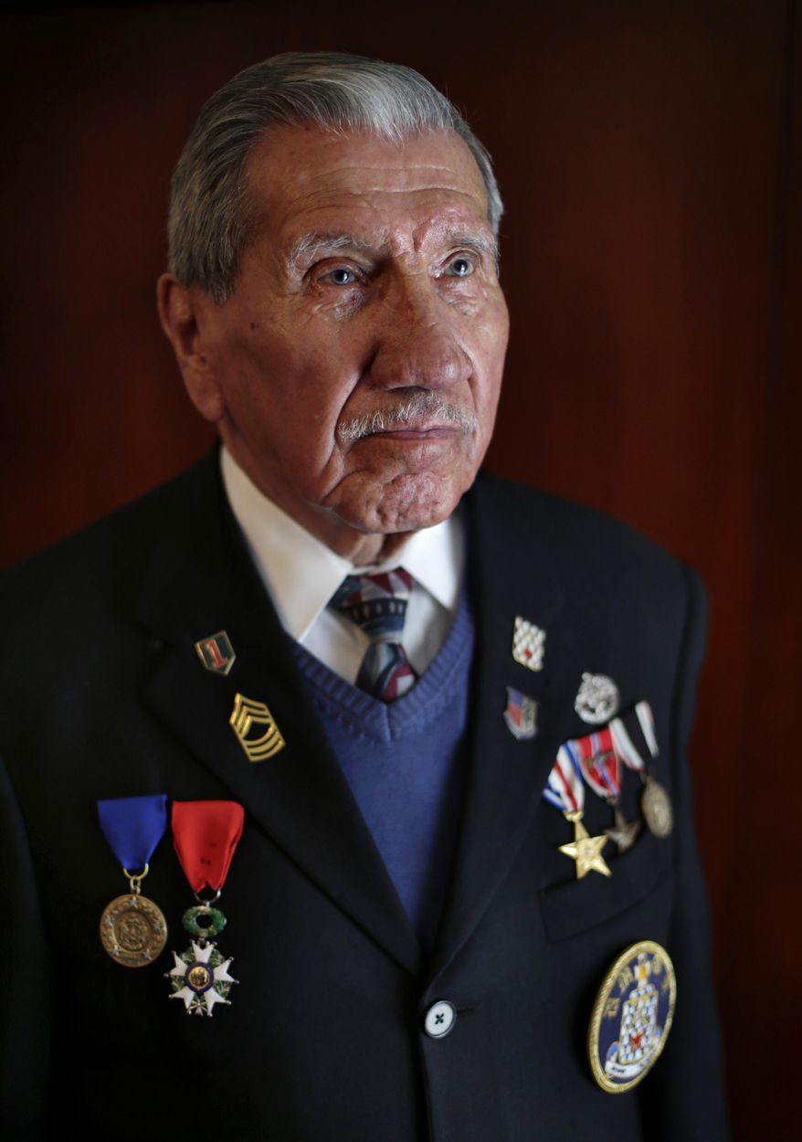 ADVANCE FOR USE MONDAY, JUNE 2, 2014, AND THEREAFTER - In this April 25, 2014 photo, D-Day survivor Charles Norman Shay, 89, poses for a photo at his home in Old Town, Maine, in the military jacket he will wear when he returns to Omaha Beach next month. Shay, a Penobscot Indian elder, served as a military medic during the invasion. He said that he plans to perform a solemn ceremony in honor of those who died at Normandy. (AP Photo/Robert F. Bukaty)