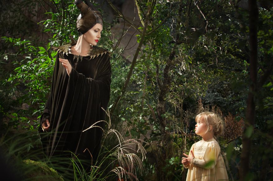 This image released by Disney shows Angelina Jolie as Maleficent, left, in a scene with her daughter Vivienne Jolie-Pitt, portraying Young Aurora, in a scene from "Maleficent." (AP Photo/Disney, Frank Connor)