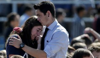 A couple embrace before a memorial service for the victims and families of Friday&#39;s rampage at Harder Stadium on the campus of University of California, Santa Barbara on Tuesday, May 27, 2014 in the Isla Vista area near Goleta, Calif. Sheriff&#39;s officials said Elliot Rodger, 22, went on a rampage near the University of California, Santa Barbara, stabbing three people to death at his apartment before shooting and killing three more in a crime spree through a nearby neighborhood. (AP Photo/Chris Carlson)
