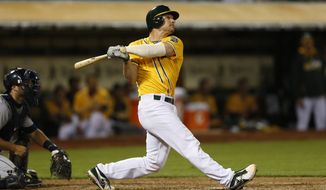 Oakland Athletics catcher John Jaso hits a two-run home run during the fourth inning of a baseball game against the Detroit Tigers, Tuesday, May 27, 2014, in Oakland, Calif. (AP Photo/Beck Diefenbach)