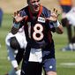 Denver Broncos Peyton Manning talks to teammates as they warmup during an NFL football organized team practice at the Broncos training facility in Englewood, Colo., on Wednesday, May 28, 2014. (AP Photo/Ed Andrieski)