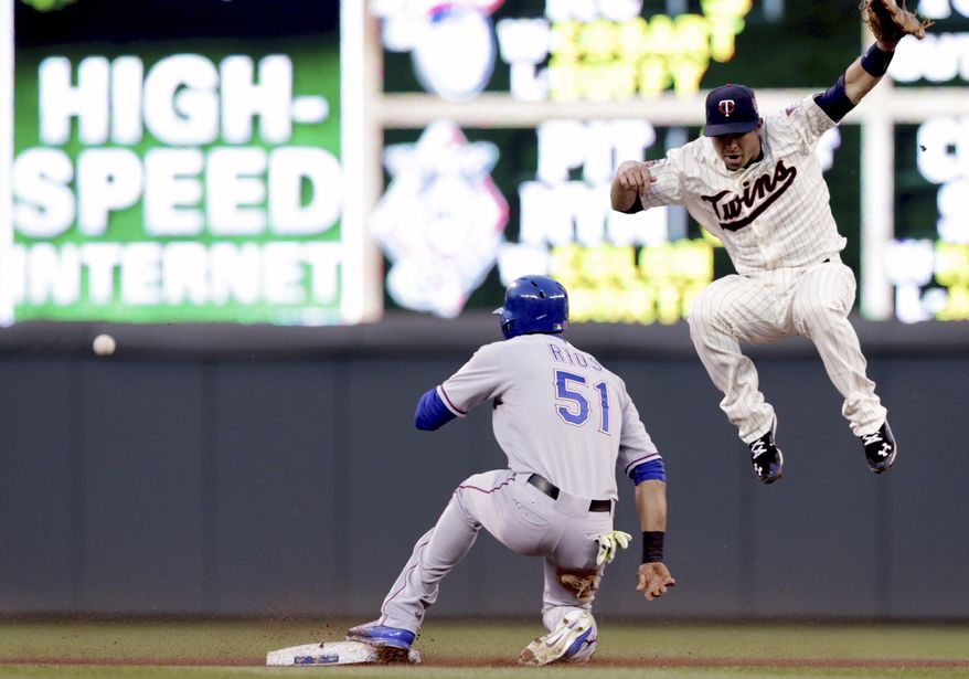 Texas Rangers' Alex Rios, left, steals second as Minnesota Twins second baseman Brian Dozier jumped unsuccessfully for the high throw in the fourth inning of a baseball game Wednesday, May 28, 2014, in Minneapolis. Rios then advanced to third on the play. (AP Photo/Jim Mone)