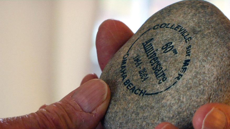 ADVANCE FOR USE MONDAY, JUNE 2, 2014, AND THEREAFTER - In this April 2, 2014 photo, D-Day survivor Ray Lambert holds a piece of "shale" from Omaha Beach at his home Seven lakes, N.C. Lambert, a combat medic, was with the 1st Infantry Division, which accounted for more than half of the 32,000-strong U.S. force that landed on Omaha Beach. (AP Photo/Allen G. Breed)
