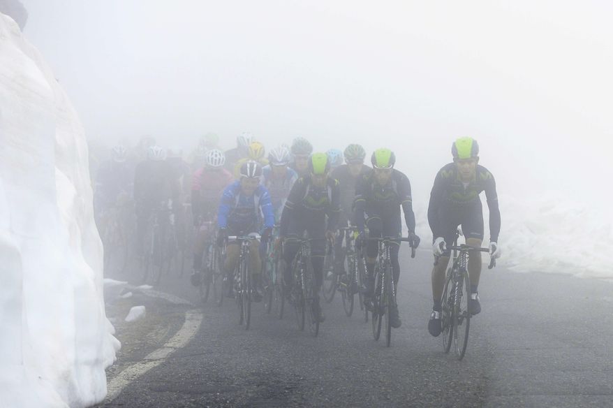 Movistar team cyclists lead the pack as they climb among fog and snow during the 16th stage of the Giro d' Italia cycling race from Ponte di Legno to Val Martello, Italy, Tuesday, May 27, 2014. Movistar's Nairo Quintana, of Colombia, won the stage and became the new leader of the race. (AP Photo/Fabio Ferrari)