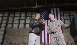 President Barack Obama, left, is introduced by Marine Gen. Joseph Dunford, commander of the US-led International Security Assistance Force (ISAF) after arriving for a troop rally during an unannounced visit to Bagram Air Field, north of Kabul, Afghanistan, on Sunday, May 25, 2014. (AP Photo/ Evan Vucci)